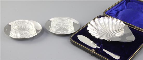A cased Victorian silver scallop shaped butter dish and knife and a pair of butter dishes, 74 grams.